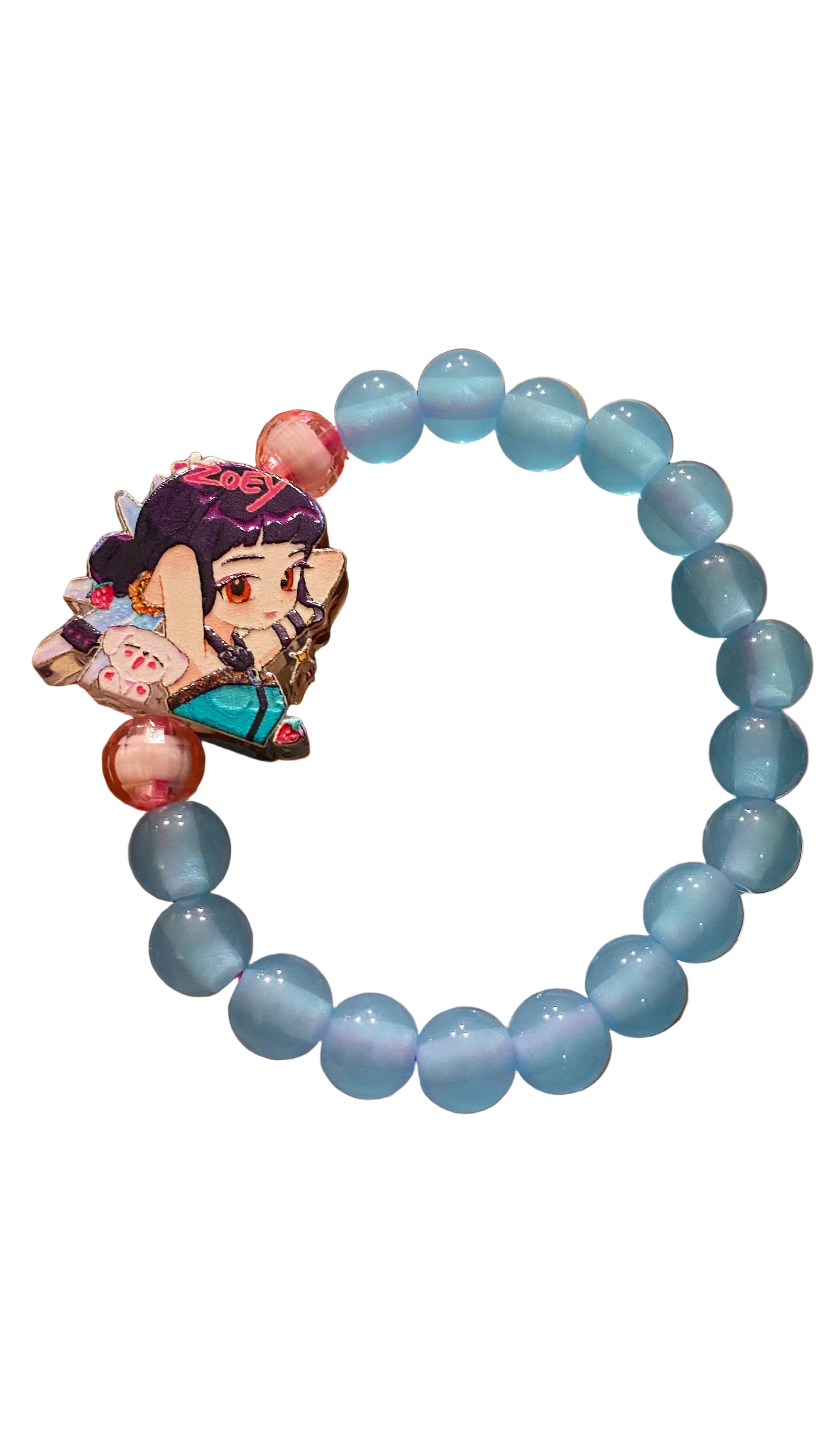 Blue beaded bracelet with a character charm held in a hand against a blurred background